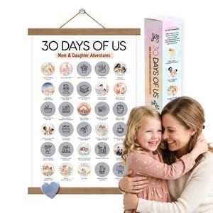May include: A wooden-framed poster titled "30 Days of Us: Mom & Daughter Adventures" with illustrated activity circles. A matching box is next to the poster. A mother and daughter are embracing in the foreground.