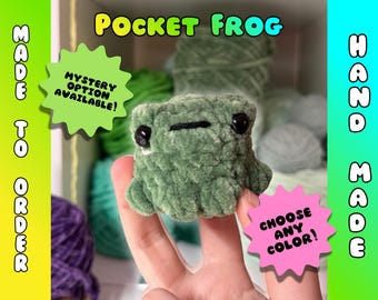 May include: A handmade, green crocheted frog with black eyes and a stitched mouth. The image includes text that reads "Pocket Frog", "Made to Order", "Hand Made", "Mystery Option Available!", and "Choose Any Color!"