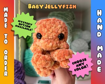 May include: Handmade orange crochet baby jellyfish plush toy with black eyes. The image includes text that says "Baby Jellyfish", "Made to Order", "Hand Made", "Mystery Option Available!", and "Choose Any Color!"