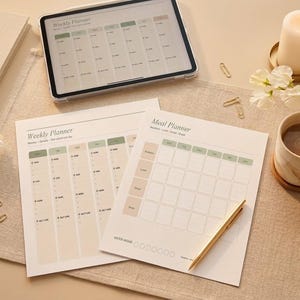 May include: A flat lay featuring a weekly planner, meal planner, and a tablet displaying a weekly schedule. A lit candle, a cup of coffee, and a pen are also present. The scene is decorated with flowers and paper clips, creating a cozy, organized aesthetic.