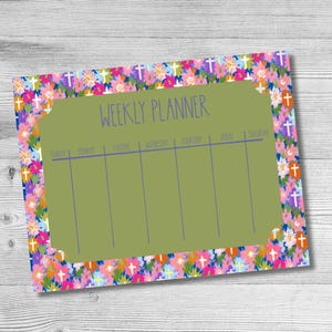 May include: A weekly planner with a rectangular olive green center featuring the text WEEKLY PLANNER and columns for each day of the week. The border is decorated with a vibrant floral pattern in shades of pink, orange, blue, and white with small crosses.