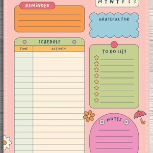 Op de afbeelding: Een roze dagplanner met de titel Today's Plan, voorzien van secties voor herinneringen, een kalender, een dagschema, een dankbaarheidslijst, een takenlijst met ster-checkboxen en een notitiegedeelte versierd met paraplu's en bloemen.