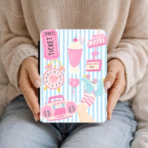 Pode incluir: Um design ilustrado em rosa e azul com um bilhete, um despertador, um milkshake, um balão em forma de coração, patins e um boombox. O design também inclui um letreiro de motel com o texto "Monterey MOTEL" e "FAMILY UNITS POOL".