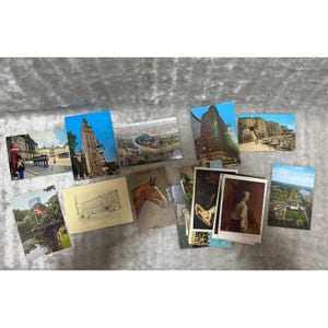 May include: A collection of assorted vintage postcards featuring various scenes including a tall stone tower, a city landscape, a skyscraper, a rocky cliff, a horse head illustration, a building sketch, and portraits of people in historical attire.
