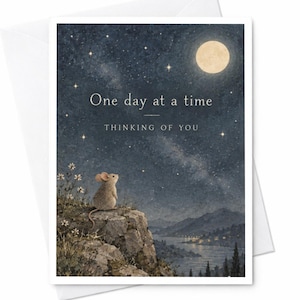 May include: A greeting card featuring a small brown mouse sitting on a rocky cliff, looking up at a starry night sky with a full moon. The text reads One day at a time and THINKING OF YOU. Below the cliff is a dark landscape with a river.