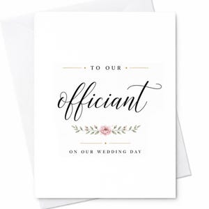May include: A white greeting card with black calligraphy text that reads TO OUR officiant ON OUR WEDDING DAY. The design features a small, centered illustration of a pink rose surrounded by green leaves, accented by thin gold horizontal lines.