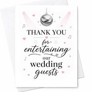May include: A white greeting card featuring a silver disco ball at the top, flanked by two pink spotlights. The text reads THANK YOU for entertaining our wedding guests in black lettering, accented by small pink hearts, purple musical notes, and stars.