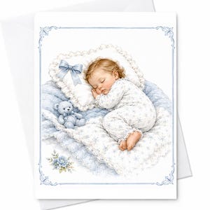 Può includere: Un biglietto d'auguri con l'illustrazione di un bambino che dorme su un cuscino bianco con un fiocco blu, appoggiato su una coperta trapuntata blu e bianca. Un piccolo orsacchiotto blu è vicino e un accento floreale blu è nell'angolo.
