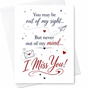 May include: A white greeting card featuring dark blue and red text that reads: You may be out of my sight... But never out of my mind... I Miss You! The design includes small red hearts, dark blue stars, a paper airplane, and an envelope icon.