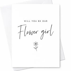 Può includere: Un biglietto bianco con la scritta "WILL YOU BE OUR Flower girl" in carattere nero. Sotto il testo c'è una piccola e semplice illustrazione floreale. Il biglietto è all'interno di una busta bianca.