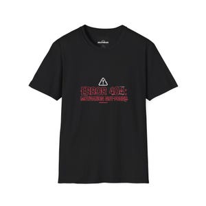 Może przedstawiać: Czarny t-shirt z krótkim rękawem z białą ikoną trójkąta ostrzegawczego nad czerwonym napisem ERROR 404: MOTIVATION NOT-FOUND. Grafika posiada cyfrowy efekt usterki i jest wyśrodkowana na klatce piersiowej odzieży.