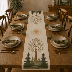 May include: A long, rectangular table runner featuring a printed design of green pine trees, a large central tree, and a sunburst motif. The runner is centered on a wooden dining table set with four place settings, each including a plate and napkin.
