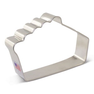 May include: A silver metal cookie cutter shaped like a pie crust. The cutter has a wavy edge and a straight bottom.