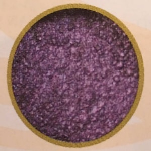 May include: A close-up of a round, purple glitter eyeshadow compact with a gold rim.