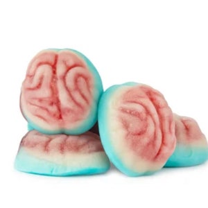 Puede incluir: Un montón de caramelos de goma con forma de cerebro. Los caramelos tienen una capa exterior azul claro, una capa central blanca y un diseño rojo en forma de cerebro en la parte superior. Los caramelos están apilados unos encima de otros.