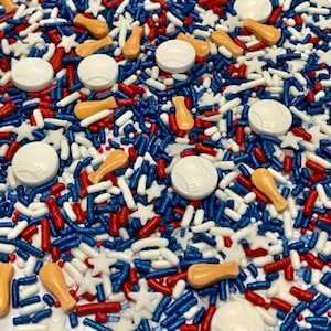 May include: A variety of colorful sprinkles in red, white, and blue, including baseballs, bats, and stars. These sprinkles are perfect for decorating cakes, cupcakes, and other treats.
