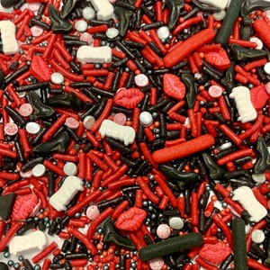 Puede incluir: Una mezcla de sprinkles rojos, negros y blancos. Los sprinkles tienen forma de labios, zapatos y otras formas divertidas.