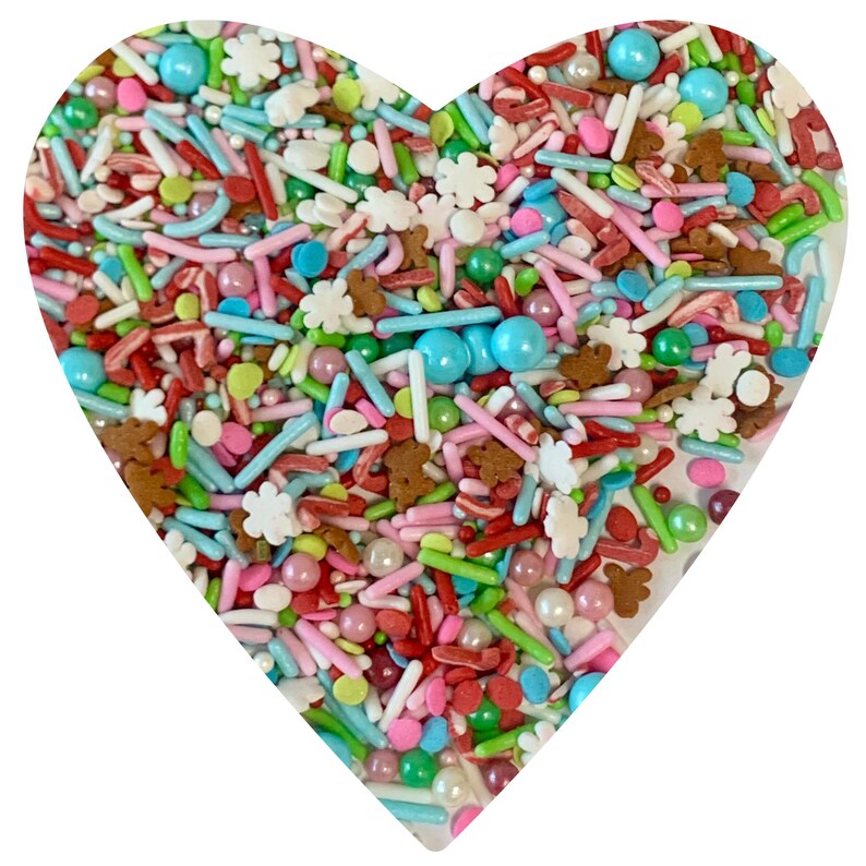 May include: A heart-shaped bowl filled with colorful sprinkles, including red and white candy canes, green and white snowflake sprinkles, and small, round, pastel-colored sprinkles.