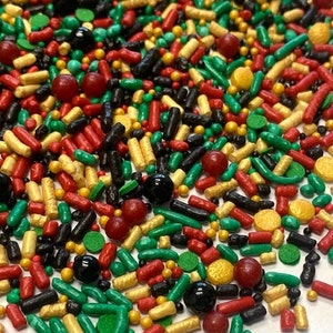 Puede incluir: Una mezcla de sprinkles rojos, verdes, dorados y negros. Los sprinkles son de varias formas, incluyendo redonda, larga y en forma de estrella.