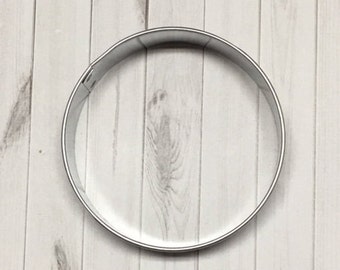 May include: A silver metal cookie cutter shaped like a circle.