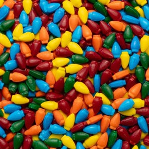 Puede incluir: Primer plano de un gran surtido de caramelos coloridos con forma de bombillas. Los caramelos son de tonos rojos, verdes, azules, amarillos y naranjas.