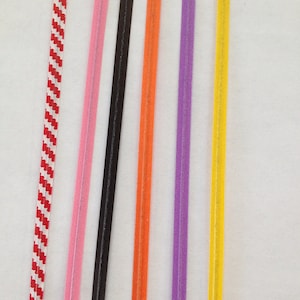 K&ouml;nnte beinhalten: Sechs unterschiedlich farbige Schn&uuml;re, darunter rot-wei&szlig; gestreift, rosa, schwarz, orange, lila und gelb.