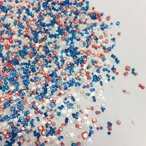 May include: Red, white, and blue sprinkles with stars, squares, and round sprinkles.
