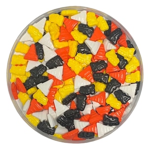 May include: A bowl of colorful sprinkles in the shape of traffic cones and construction vehicles. The sprinkles are in shades of orange, yellow, black, and white.