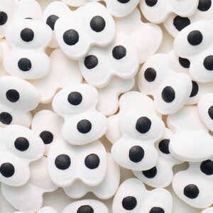 以下が含まれることがあります： 黒い中心を持つ目のような形をした白い砂糖クッキーの飾り。ケーキ、カップケーキ、クッキーのデコレーションに最適です。
