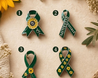 May include: Four green ribbon pins with yellow accents. One pin features a sunflower and a wheelchair symbol. Another pin has the words "IN DISABILITY VISIBLE". The other two pins have yellow flower designs.
