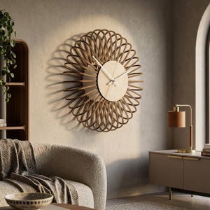 Pode incluir: Um relógio de parede circular com um mostrador central de madeira clara e ponteiros brancos finos, rodeado por uma moldura decorativa composta por múltiplos anéis de madeira castanho-escura sobrepostos num padrão radial.