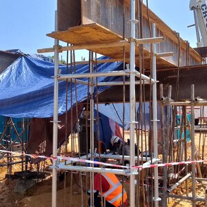 以下が含まれることがあります： 黒い持ち手と「But First, Coffee」のテキストが黒い太字でプリントされた白いセラミックマグ。 マグカップはニュートラルな背景に置かれ、シンプルなデザインが際立っています。