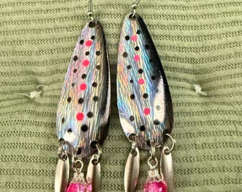 Pendientes con forma de señuelo de pesca: iridiscentes, rosa fucsia, negros, plateados y con ganchos de acero inoxidable quirúrgico.