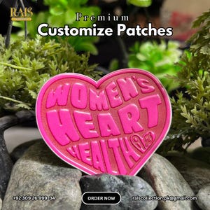 Op de afbeelding: Een hartvormige patch in felroze met een getextureerd oppervlak. De tekst "WOMEN'S HEART HEALTH" is in dikke, verhoogde roze letters in het midden gedrukt. Een klein hartsymbool is zichtbaar aan het einde van het woord "HEALTH".