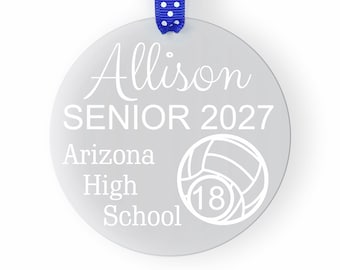 May include: A gray round ornament with a white ribbon. The ornament has the text "Allison Senior 2027 Arizona High School" and a volleyball with the number 18.