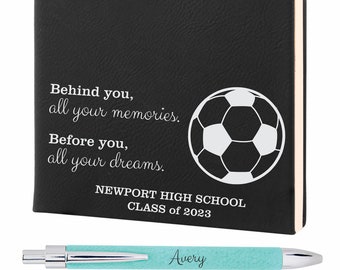 May include: Black leather journal with a white soccer ball graphic and the text "Behind you, all your memories. Before you, all your dreams. NEWPORT HIGH SCHOOL CLASS of 2023". The journal is personalized with the name "Avery" and the number "#23". A turquoise pen with the name "Avery" is included.