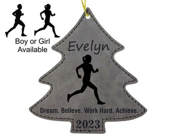 Könnte beinhalten: Grauer Filz-Weihnachtsbaumschmuck mit einer laufenden Silhouette, dem Namen "Evelyn" und dem Text "Dream. Believe. Work Hard. Achieve." und dem Jahr "2023".
