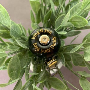May include: Black bicycle bell with gold lettering that reads "Ring if you love your Daddy".