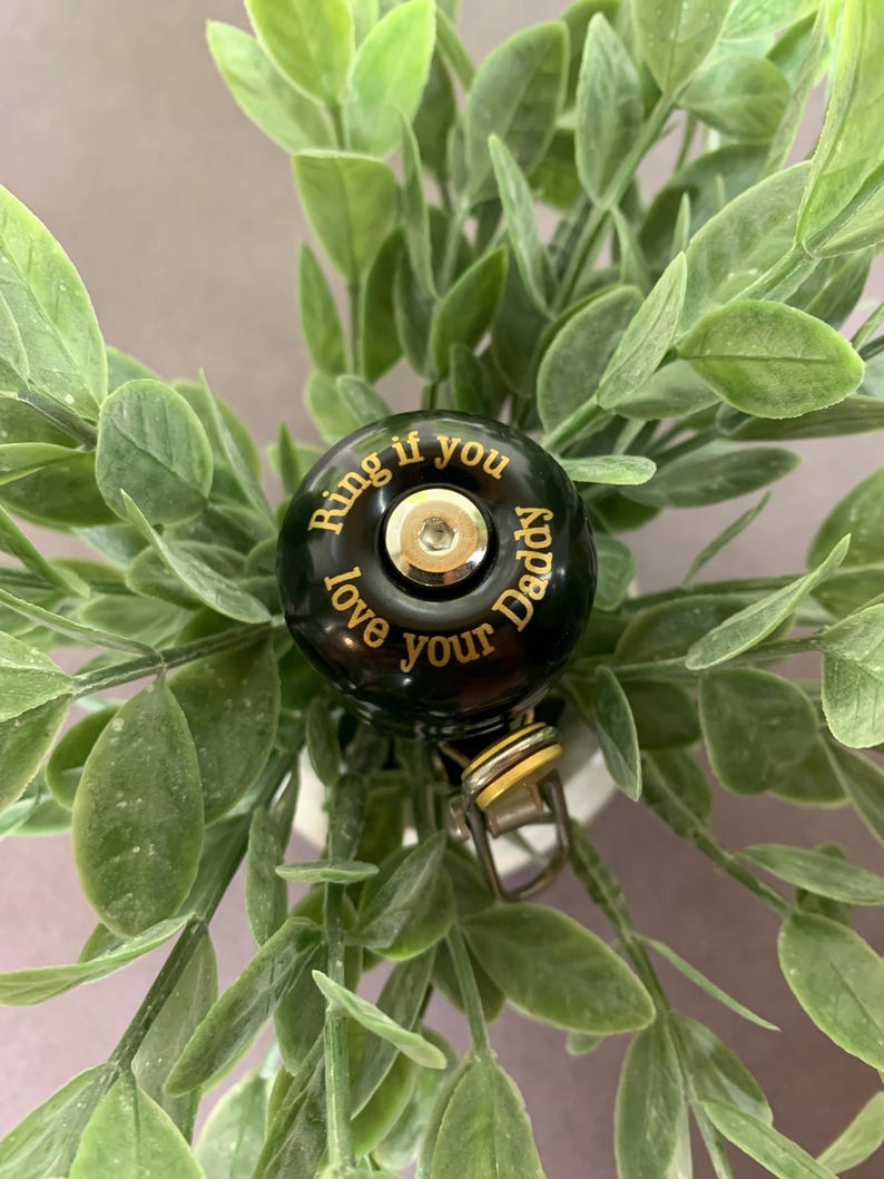 May include: Black bicycle bell with gold lettering that reads "Ring if you love your Daddy".