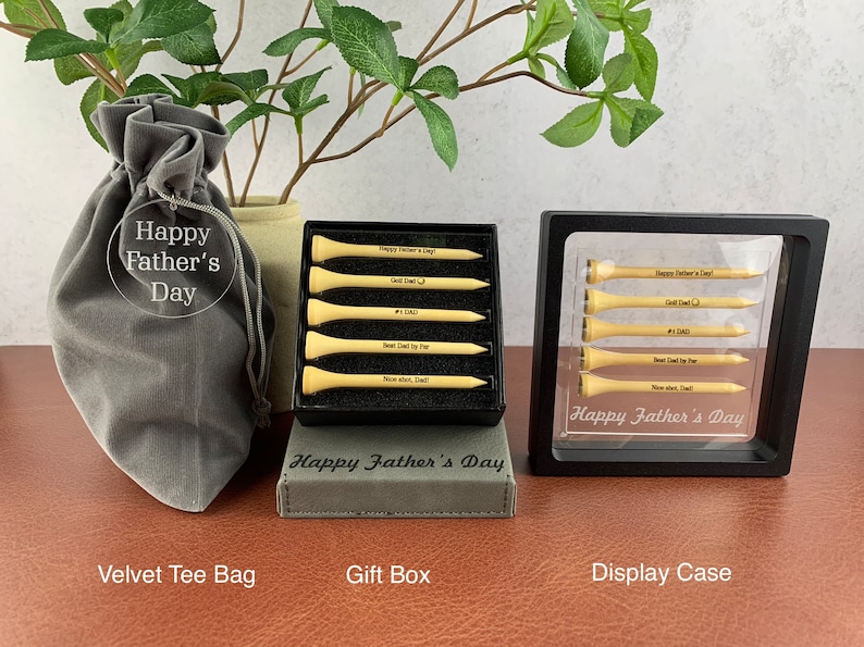 May include: A set of six personalized golf tees in a black gift box with a gray velvet bag. The tees are engraved with the text "Happy Father's Day", "Golf Dad", "#1 Dad", "Best Dad by Far", "Nice Shot, Dad!" and "Happy Father's Day".