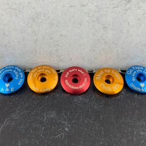 May include: Five different colored metal bike stem caps with personalized engravings. The engravings include messages of love, appreciation, and humor.