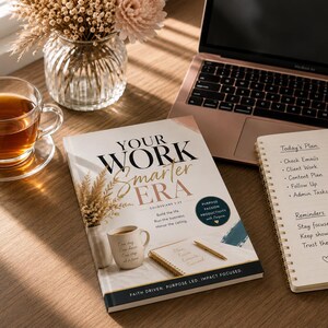 Op de afbeelding: Een werkplek met een laptop, een notitieboekje met een takenlijst en een boek met de titel "Your Work Smarter Era". Een kopje thee en een vaas met bloemen zijn ook aanwezig. De sc&egrave;ne speelt zich af op een houten oppervlak.