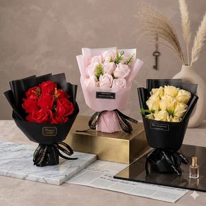 以下が含まれることがあります： 赤、薄ピンク、黄色の3つのバラのブーケ。 各ブーケは装飾紙で包まれ、リボンで結ばれています。 赤いブーケは黒い包み紙、ピンクのブーケはピンクの包み紙、黄色のブーケは黒い包み紙です。