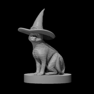 May include: A gray monochromatic figurine of a seated cat wearing a pointed witch hat with a buckle detail. The cat is positioned on a circular base, featuring detailed fur texture and a smooth, matte finish throughout the entire sculpted object.