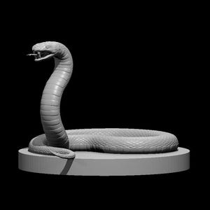 May include: A gray, three-dimensional model of a cobra snake in a striking pose with its hood flared and mouth open, revealing fangs and a forked tongue. The snake is coiled on a circular, flat-topped base against a solid black background.