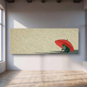 以下が含まれることがあります： 雨の中で赤い傘の下にいる緑色のカエルを描いた長方形のキャンバスプリント。 カエルは傘を持っており、背景は雨を表す斜めの線が入ったベージュ色です。