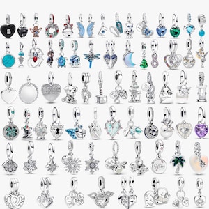 May include: A selection of silver charm pendants with diverse designs, such as hearts, animals, and celestial themes. Some charms have colourful accents like turquoise, blue, and green. These pendants are designed for bracelets or necklaces.