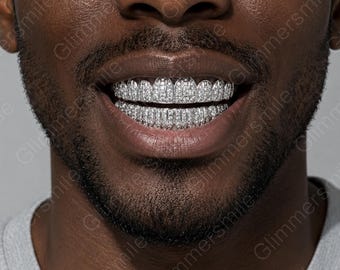 May include: A set of silver-toned dental grills covering the upper and lower teeth, featuring a dense pavé setting of small, clear, reflective stones. The word Glimmersmile is repeated as a watermark across the image.