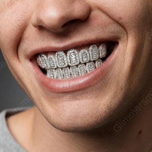 May include: Close-up of a person smiling, showcasing custom-fitted diamond grillz. The grillz are silver-toned and encrusted with numerous small, sparkling diamonds, creating a dazzling effect. The design covers the upper and lower teeth.
