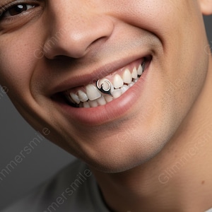 May include: A close-up of a person smiling, showcasing a silver tooth gem. The gem is a curved design, adding a unique accent to the teeth. The background is a soft gray, highlighting the person's smile and the tooth accessory.